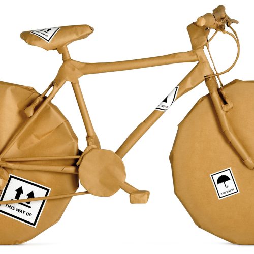 bicycle wrapped in brown paper ready for an office move isolated on a white background